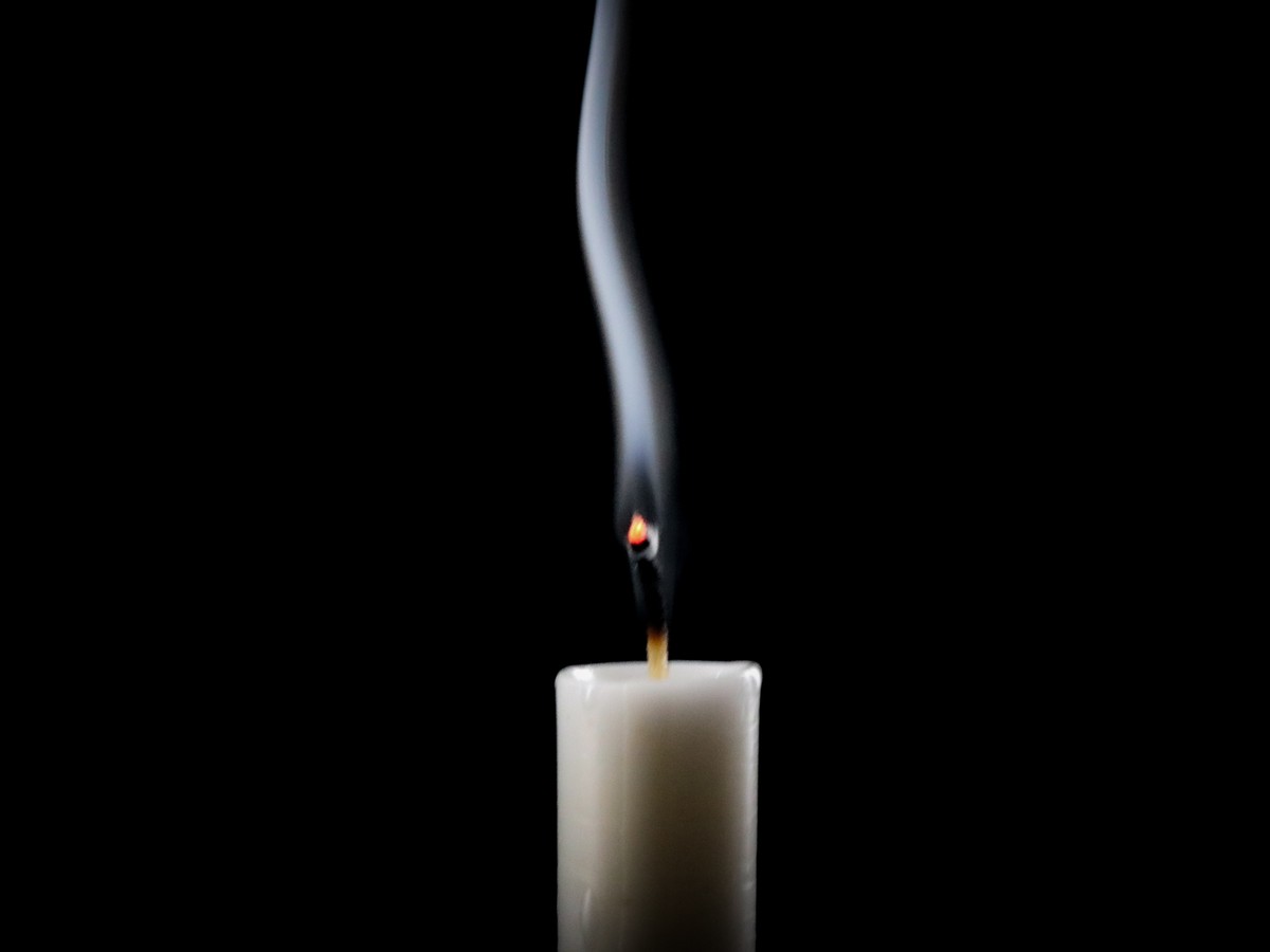 Candle,Extinguished,,Smoke,Rising,Against,Black,Background.