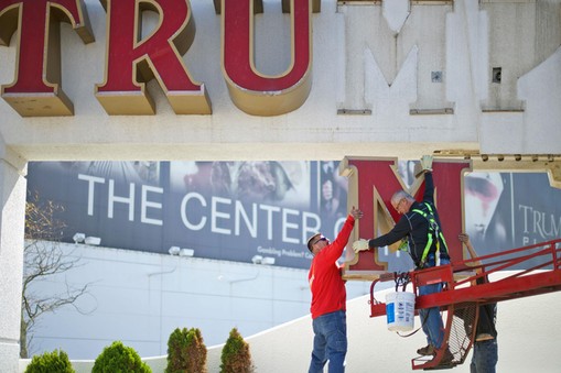 Williams, of Calvi Electric, lowers the 'M' letter from the signage of Trump Plaza Casino to his co-