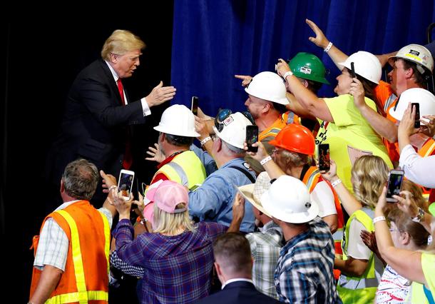 U.S. President Donald Trump greets people as he arrives for a Make America Great Again rally in Grea