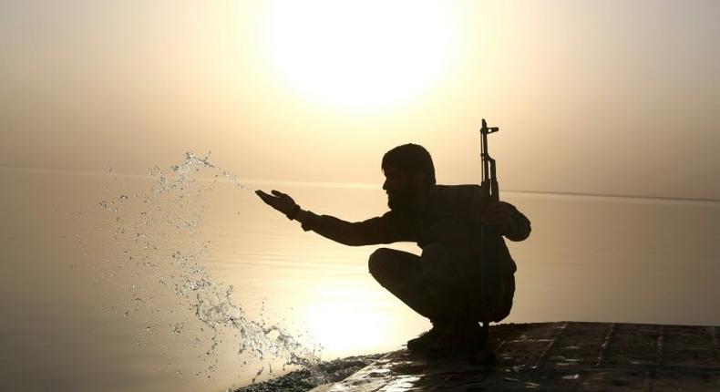 A member of the US-backed Syrian Democratic Forces splashes water at Lake Assad on April 29, 2017