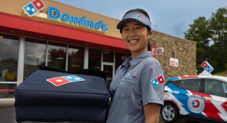 A Domino's employee prepares to deliver pizza.Domino's
