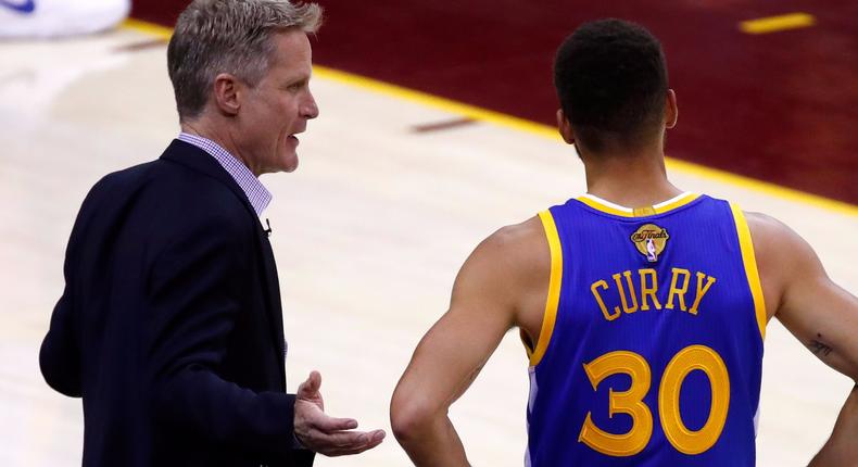 Steve Kerr and Stephen Curry of the Golden State Warriors discuss the play against the Cleveland Cavaliers during the first half in Game 4 of the 2017 NBA Finals.