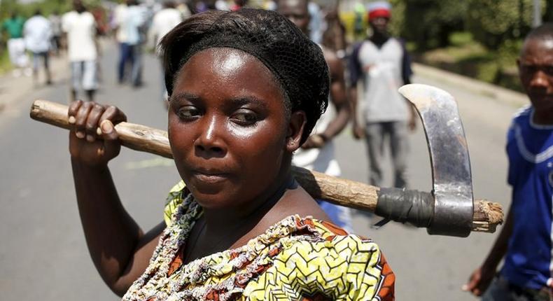 A woman carries an axe during a protest against the president in Bujumbura.