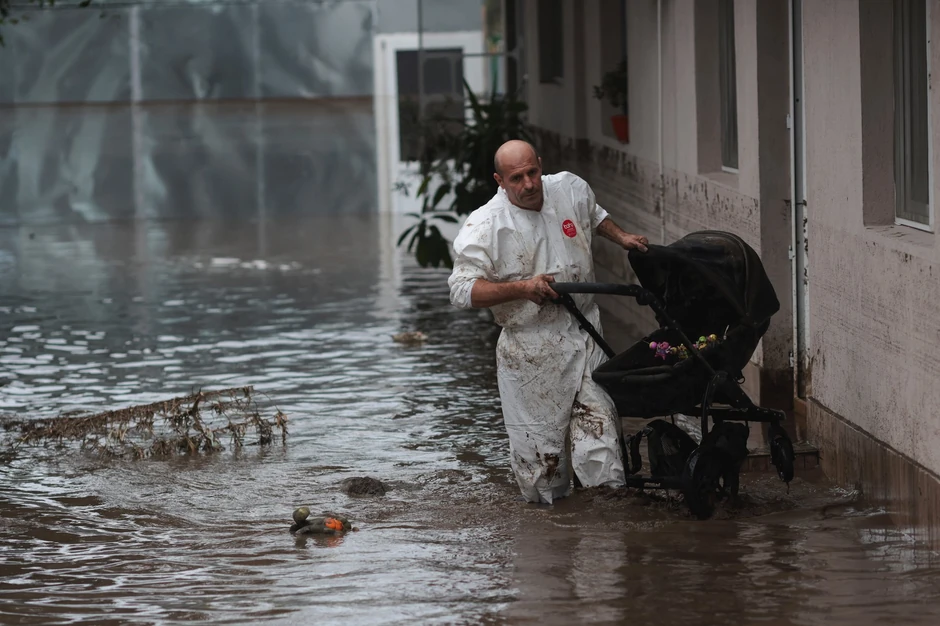 Meštanin sela Slobozije Konači, u rumunskom regionu Galac, nosi kolica kroz poplavljeno dvorište | Foto: Reuters