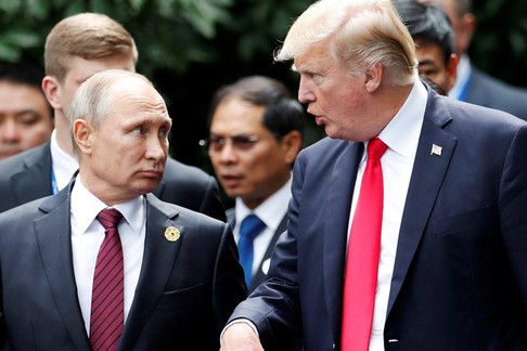 FILE PHOTO: U.S. President Donald Trump and Russia's President Vladimir Putin talk during the family