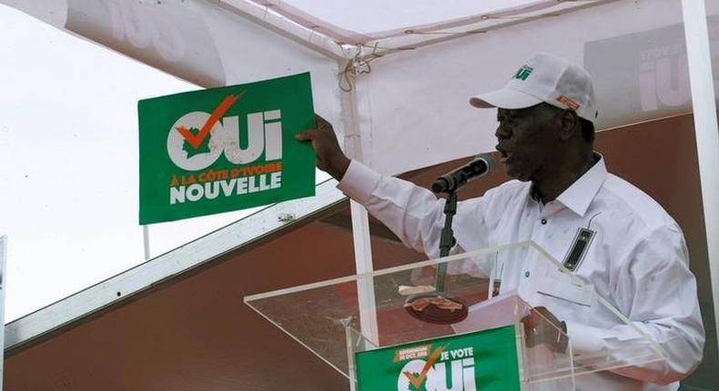 Ivory Coast's President Alassane Ouattara holds a placard as he speaks during a rally, ahead of the referendum of a new constitution, in Abidjan, October 22, 2016.The placard reads yes to new Ivory Coast. 