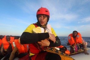 Spanish rescuer Daniel Calvelo carries a four-day-old baby girl into a RHIB, during a search and rescue operation by Spanish NGO Proactiva Open Arms, in central Mediterranean Sea, some 22 nautical miles north of the Libyan town of Sabratha