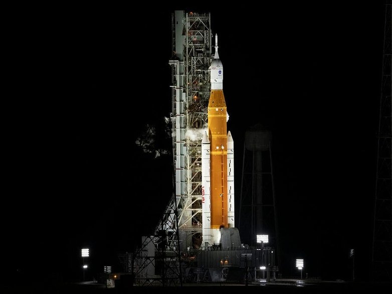 Rakieta systemu Space Launch System (SLS) agencji NASA ze statkiem kosmicznym Orion, widziana na szczycie ruchomej wyrzutni na platformie startowej 39B, w poniedziałek 29 sierpnia 2022 r. 