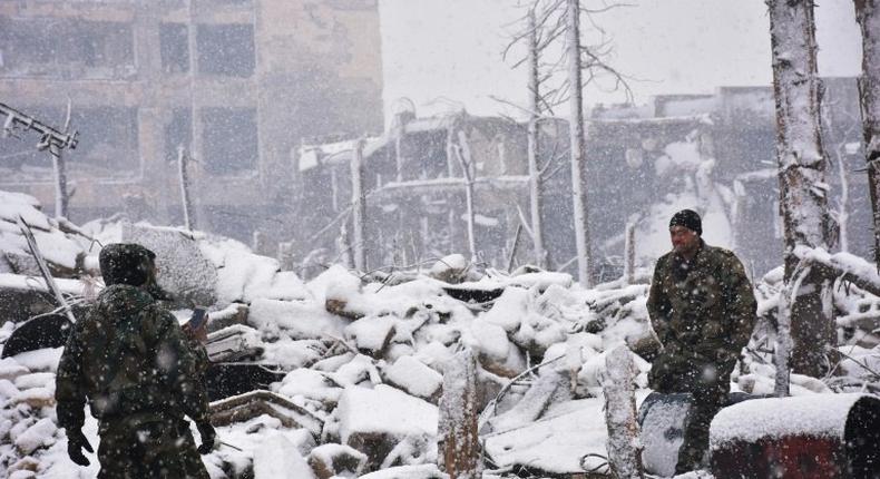 Syrian troops walk in the snow in Aleppo on December 21, 2016