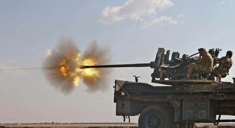 Fighters from the Free Syrian Army fire an anti-aircraft machine gun mounted on a vehicle as they battle the Islamic State (IS) group jihadists in the northern Syrian village of Yahmoul, on October 10, 2016