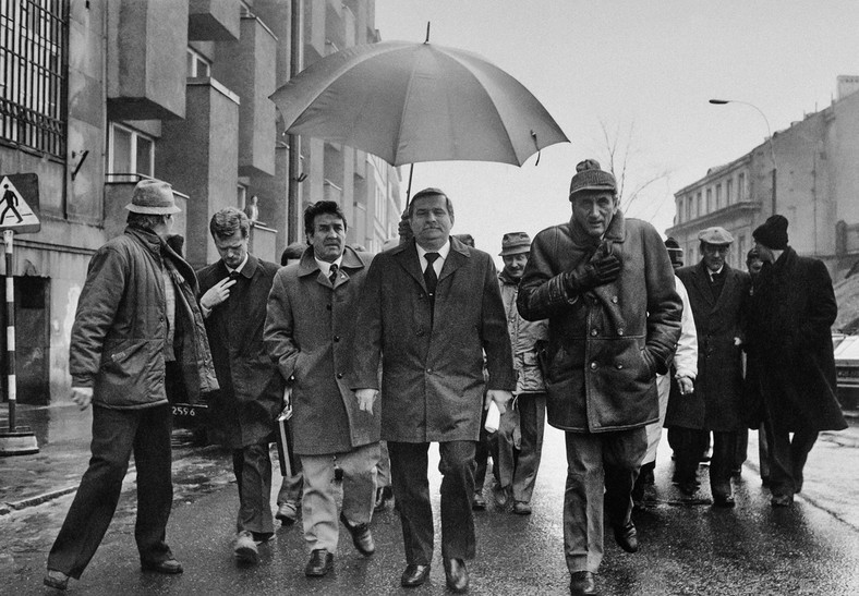 Delegacja "Solidarności" w drodze do Pałacu Namiestnikowskiego w Warszawie na rozpoczęcie obrad Okrągłego Stołu. Na zdjęciu: Lech Wałęsa (pod parasolem), Tadeusz Mazowiecki (pierwszy z prawej), Piotr Nowina-Konopka (drugi z lewej) (6 lutego 1989)