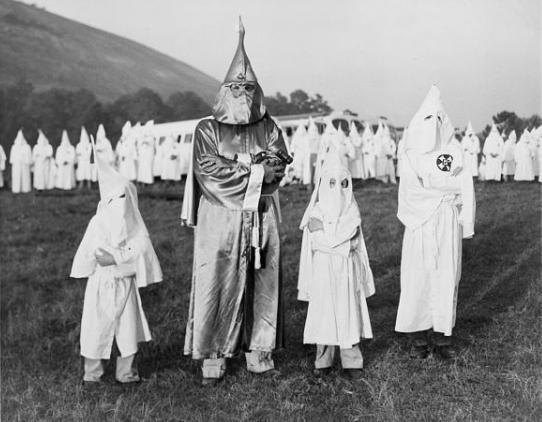 Dzieci w kostiumach Ku Klux Klanu obok jednego z przywódców Samuela Greena, lipiec 1948