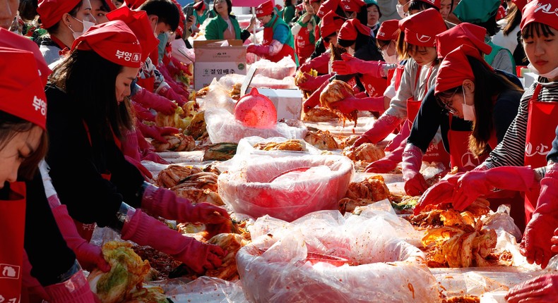 People making the traditional Korean side dish kimchi, or fermented cabbage, during the Seoul Kimchi Festival in central Seoul, South Korea.