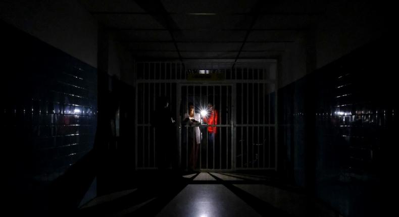 People stand on a dark corridor at Miguel Perez Carreno hospital, in Caracas, during the worst power outage in Venezuela's history