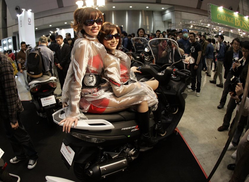 Models pose on Malaguti's Madison3 250 ie at the Tokyo Motorcycle Show