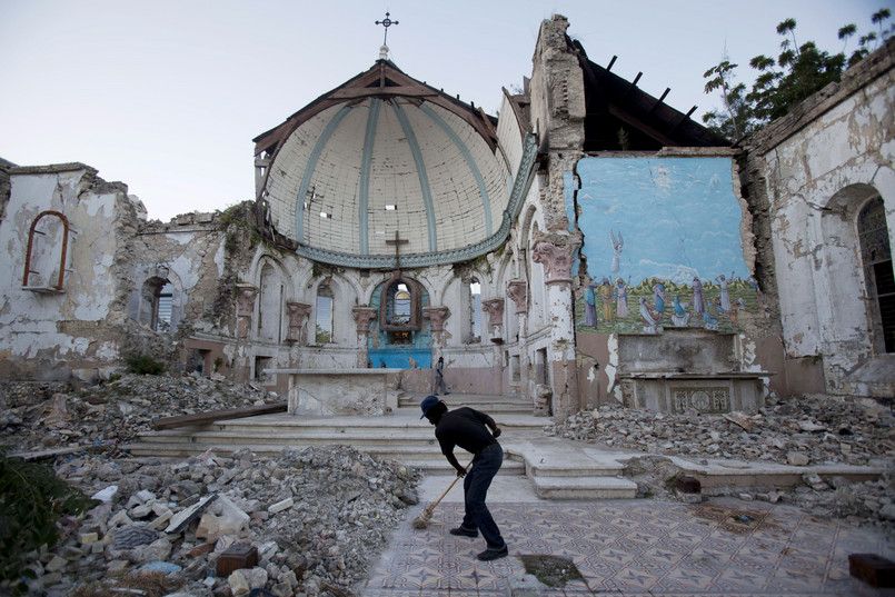 Mężczyzna porządkuje ruiny kościoła Santa Ana w Port-au-Prince