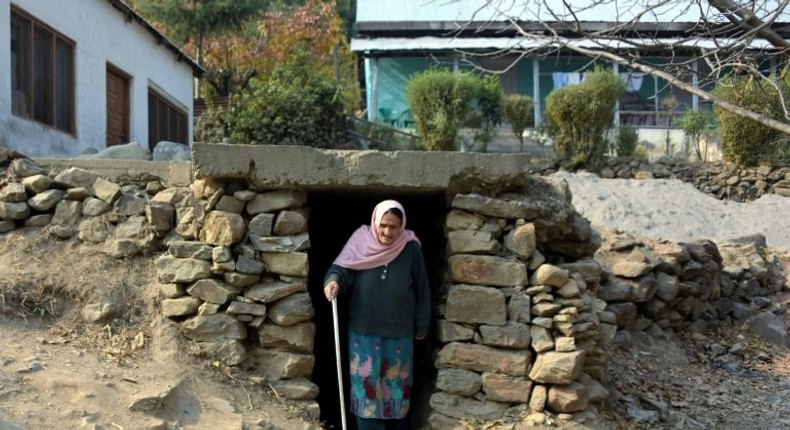 A Pakistani Kashmiri woman walks out of an underground bunker in Athmuqam village on the Line of Control, the de facto border between Pakistan and India,