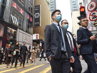 Piesi w Hongkongu w maskach ochronnych po potwierdzeniu pierwszych przypadków infekcji koronawirusem w tym mieście, 23 stycznia 2020