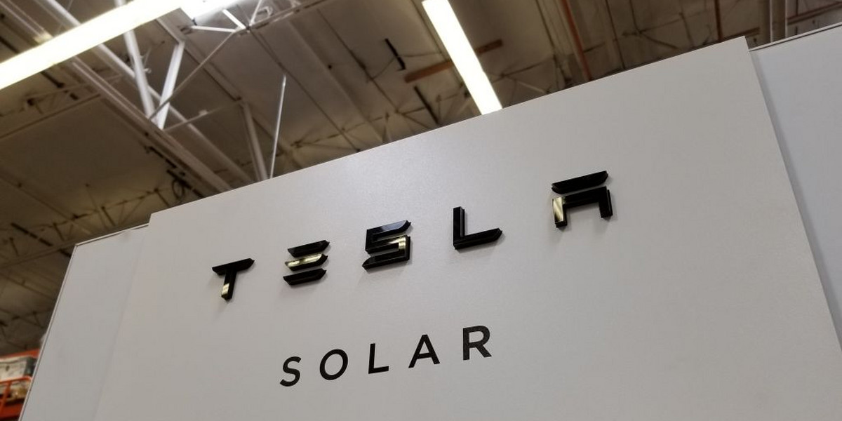 Logo Tesla Solar, technologii paneli słonecznych, które montować na własnym dachu. Sieć sklepów Walmart pozywa Teslę zarzucając panelom słonecznym jej produkcji szereg wad.