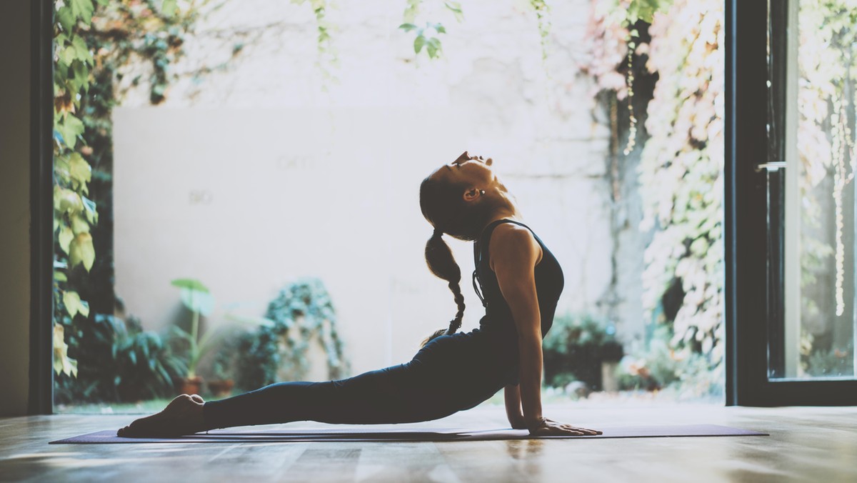 Portrait of gorgeous young woman practicing yoga indoor. Beautiful girl