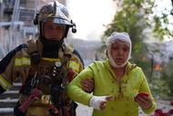 Ratownik pomagający poszkodowanej osobie w miejscu ostrzału w Kijowie, 10.10.2022 r.