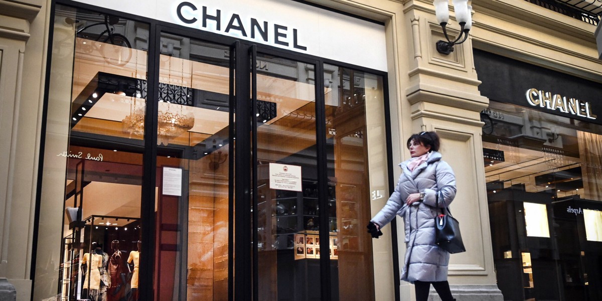 Kobieta przechodzi obok zamkniętego sklepu Chanel w Moskwie 10 marca 2022 r. Wiele luksusowych marek zawiesiło działalność w Rosji, w tym Chanel, Hermes, Prada i LVMH.