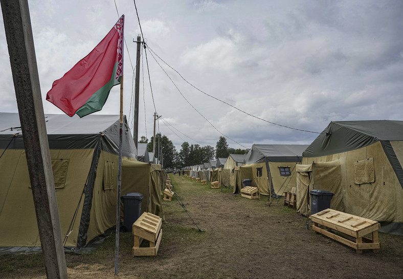 Białoruska flaga narodowa powiewa w pobliżu namiotów w białoruskim obozie wojskowym w pobliżu wsi Cel, około 90 km na południowy wschód od Mińska, Białoruś, 7 lipca 2023 r.
