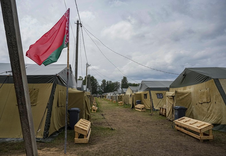 Białoruska flaga narodowa powiewa w pobliżu namiotów w białoruskim obozie wojskowym w pobliżu wsi Cel, około 90 km na południowy wschód od Mińska, Białoruś, 7 lipca 2023 r.