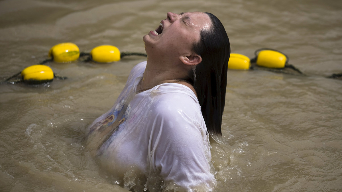 A Christian pilgrim dips in the water during her visit to the baptismal site known as Qasr el-Yahud near the West Bank city of Jericho