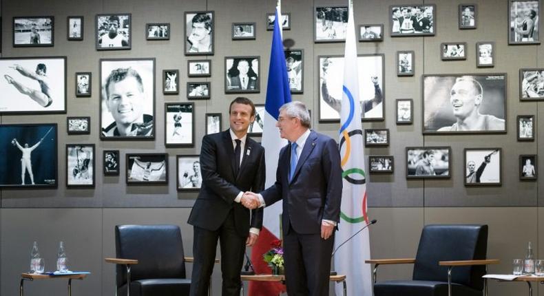 French President Emmanuel Macron (L) and International Olympic Committee President Germany's Thomas Bach visit the Olympic Museum in Lausanne on July 10, 2017