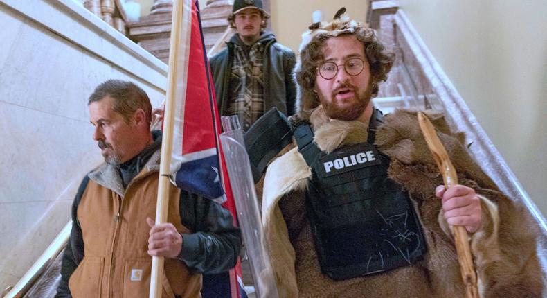 In this Jan. 6, 2021 file photo, supporters of President Donald Trump, including Aaron Mostofsky, right, who is identified in his arrest warrant, walk down the stairs outside the Senate Chamber in the U.S. Capitol, in Washington.