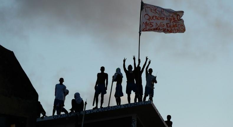 Prisioners atop the roof of the compound celebrate the transfer of their leaders after a negotiation with the police at the Alcacuz Penitentiary, near Natal, on January 16, 2017