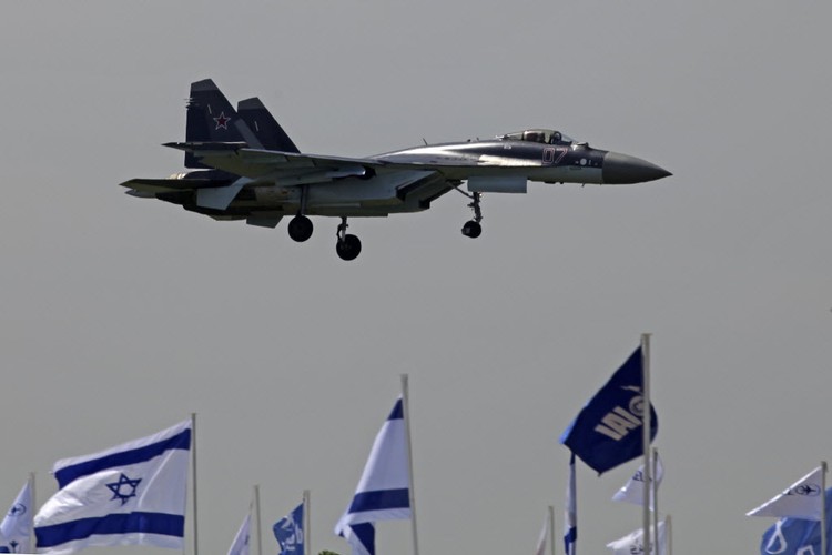 Zainteresowanie gości Paris Air Show 2013 budzą też maszyny wojskowe. Tutaj: OAO SU-35 produkowany przez Sukhoi Co. Holding szykujący się do lądowania nad powiewającymi izraelskimi flagami.