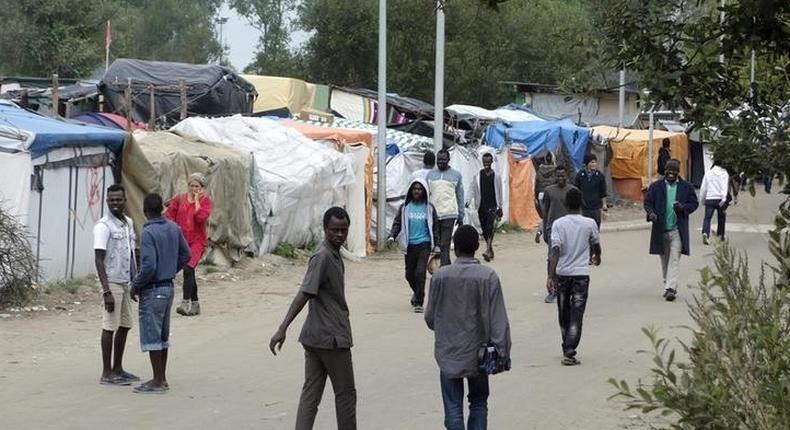 Migrants walk in the northern area of the camp called the Jungle in Calais, France, September 6, 2016. 