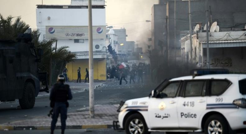 Protesters throw stones towards riot police during clashes in the Shiite village of Shahrakkan, south of Manama on April 5, 2016 following the funeral of a 17-year-old whose family says he died of injuries suffered in a police chase