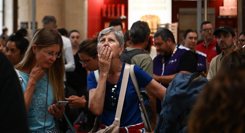 A woman looks at an information screen as passengers wait for their train departures at the Bordeaux-Saint-Jean train station in Bordeaux, western France on July 26, 2024.CHRISTOPHE ARCHAMBAULT