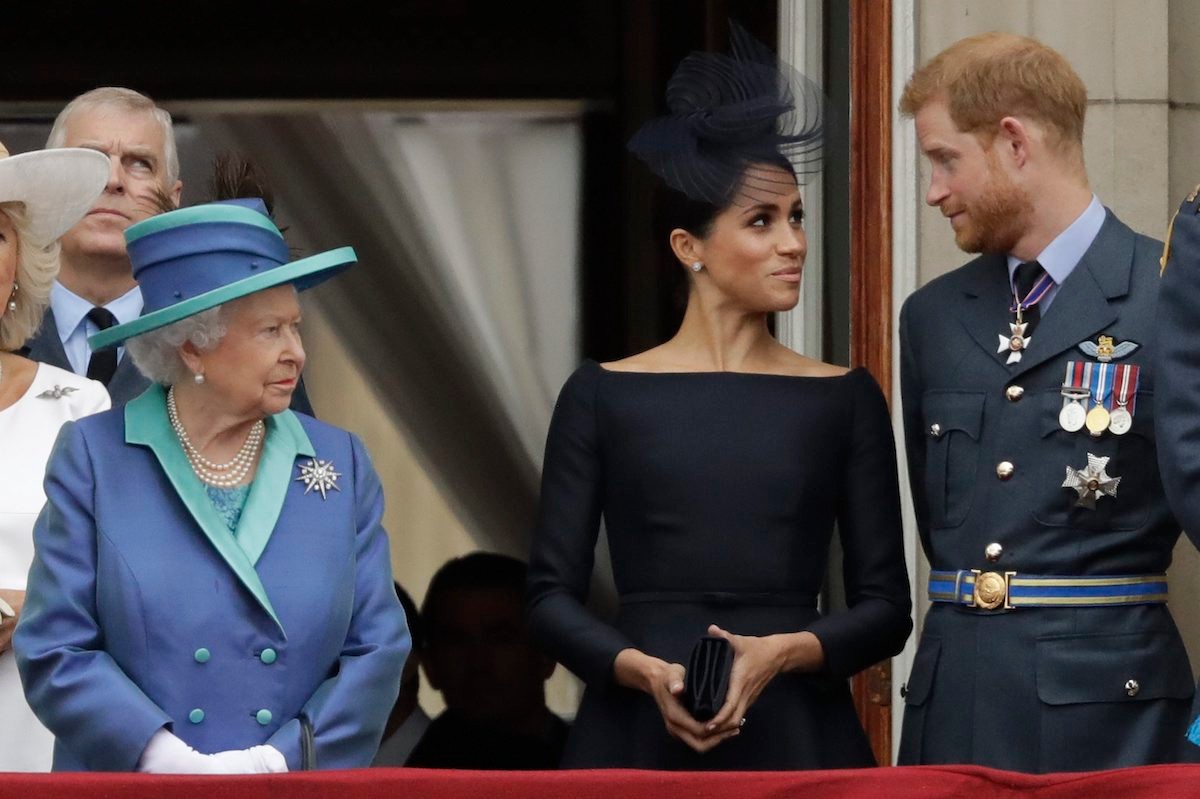 Britská kráľovná Alžbeta II. s princom Harrym a jeho manželkou Meghan. 