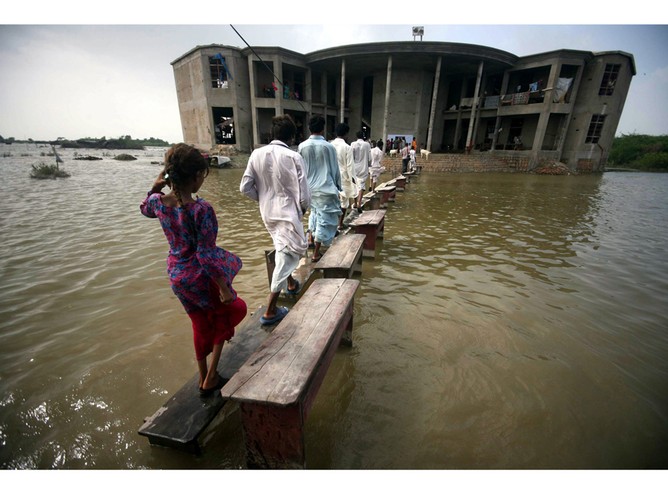 Powodzianie z Khoski, prowincji Sindh w Pakistanie, w drodze do wyżej położonej części wioski. Liczba osób poszkodowanych w powodzi wyniosła ponad 7 mln. 17 września 2011