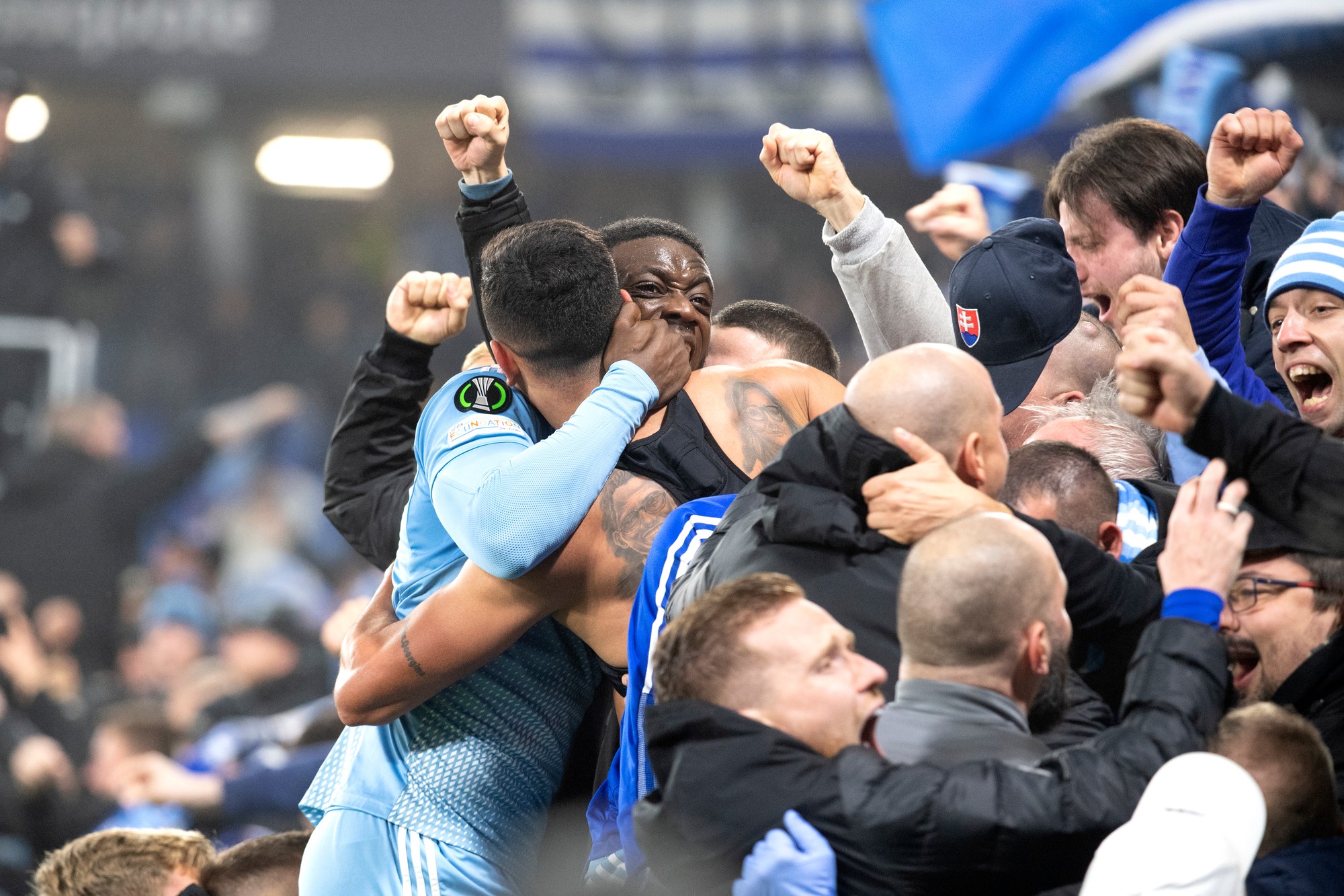 Futbalisti Slovana Eric Ramirez (chrbtom) a Myenty Abena sa tešia medzi fanúšikmi po strelení gólu.