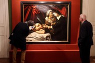 Visitors looks at a painting entitled Judith Beheading Holofernes during its presentation in Paris