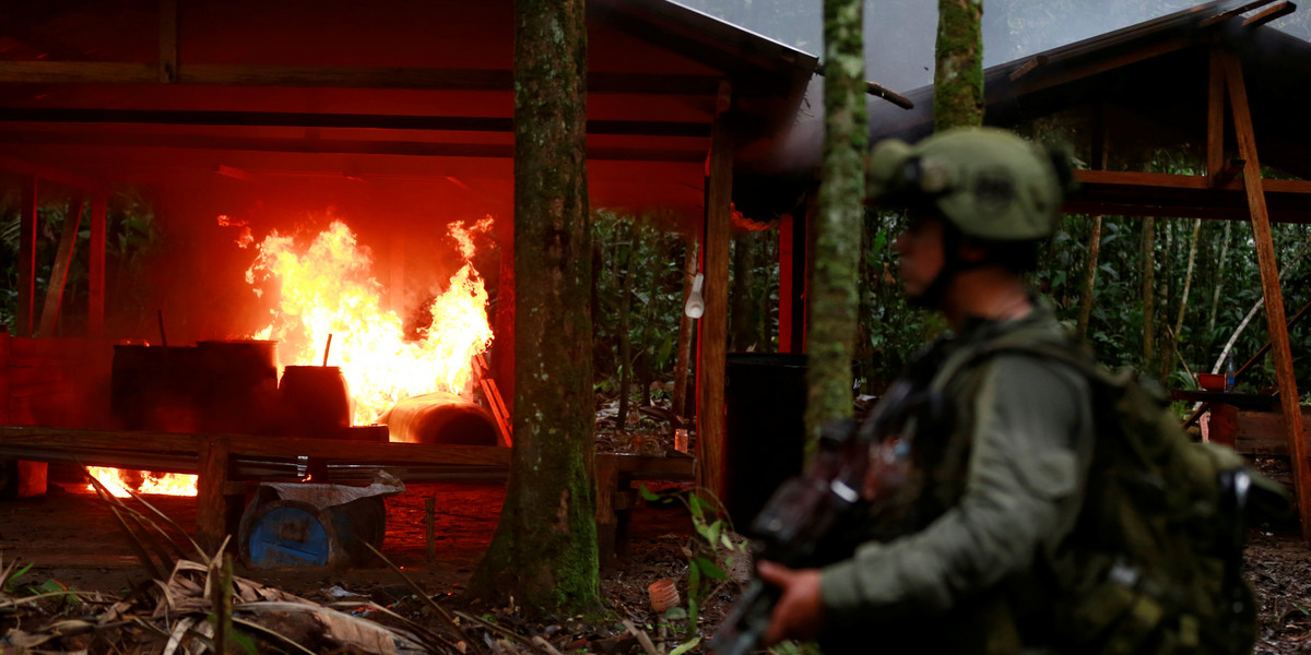 A Colombian antinarcotics policeman stands guard after burning a cocaine lab, which police said belongs to criminal gangs, in a rural area of Calamar in Guaviare state, Colombia, August 2, 2016.