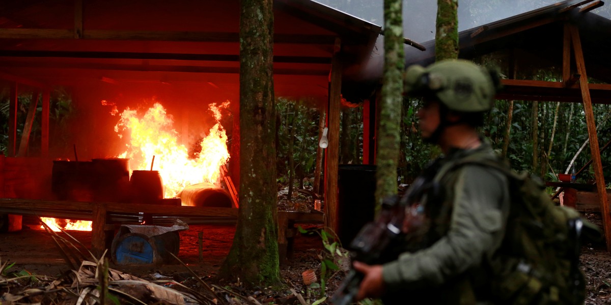 A Colombian antinarcotics policeman stands guard after burning a cocaine lab, which police said belongs to criminal gangs, in a rural area of Calamar in Guaviare state, Colombia, August 2, 2016.