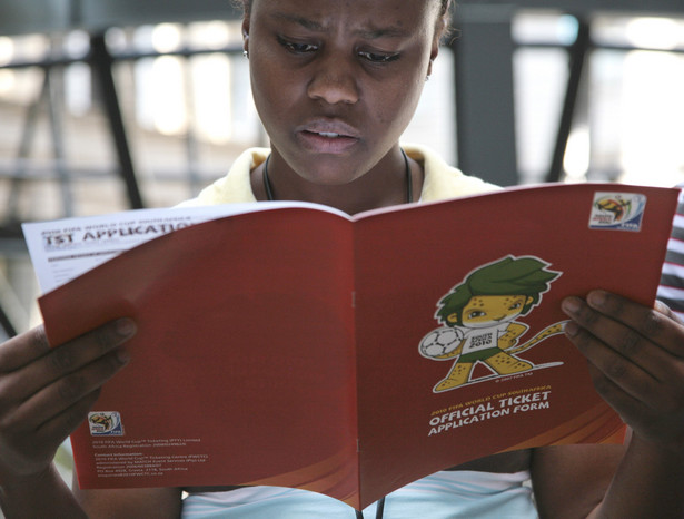 Kobieta czyta oficjalny poradnik dotyczący zasad kupowania biletów na Mundial w RPA