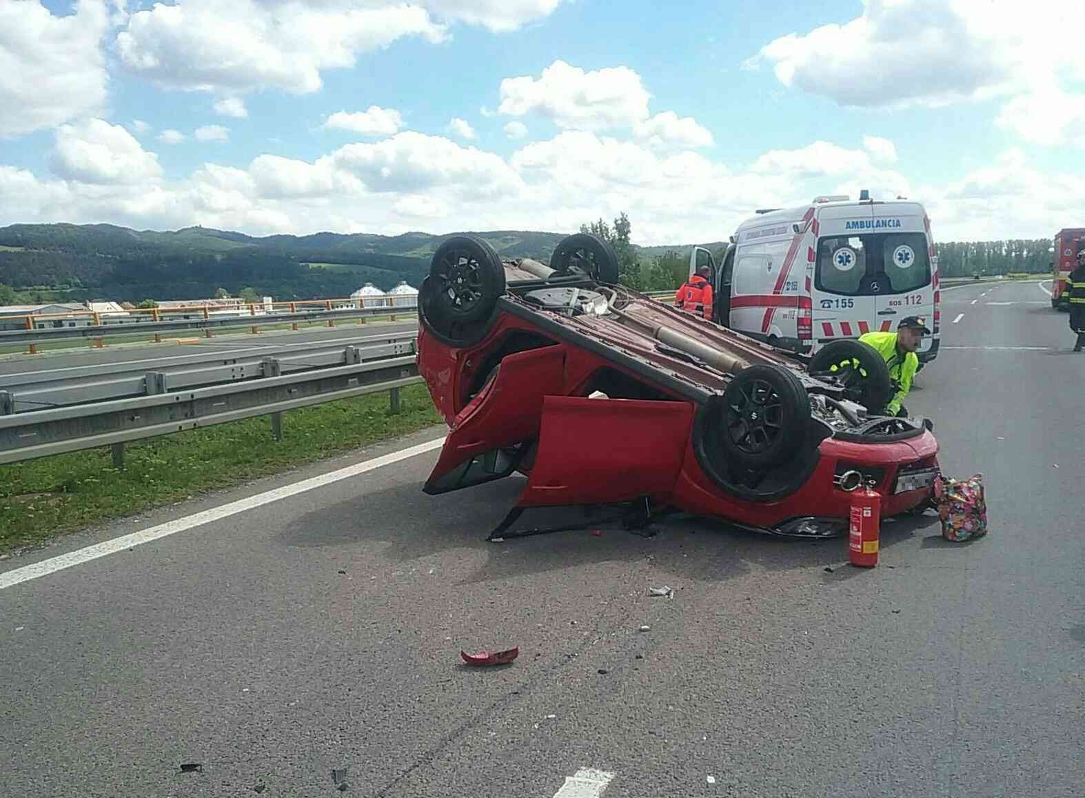 Po nehode troch vozidiel na diaľnici zostalo auto prevrátené na strechu.