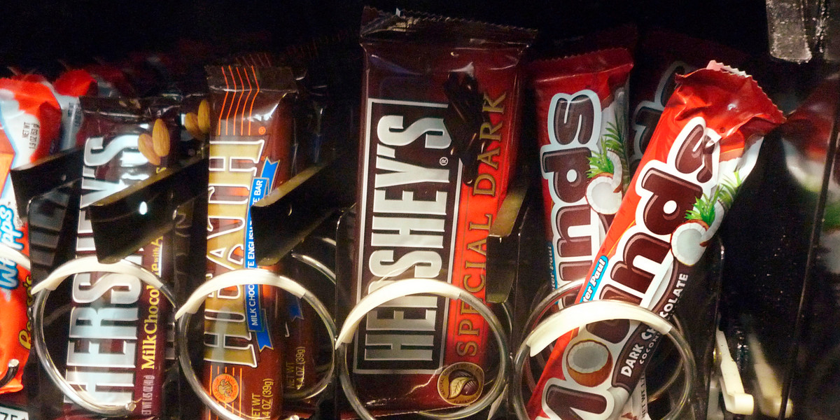 A row of candy bars manufactured by Hershey is seen in a vending machine.