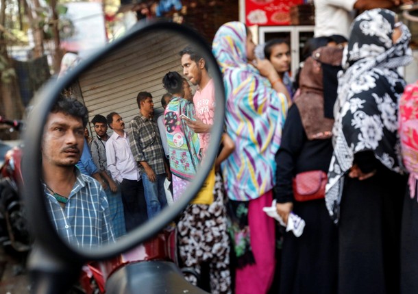 People queue outside a bank to withdraw cash and deposit their old high denomination banknotes in Mu