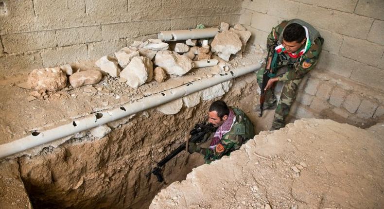 A Peshmerga fighter fires a warning shot into an Islamic State tunnel in Bashiqa on November 9, 2016