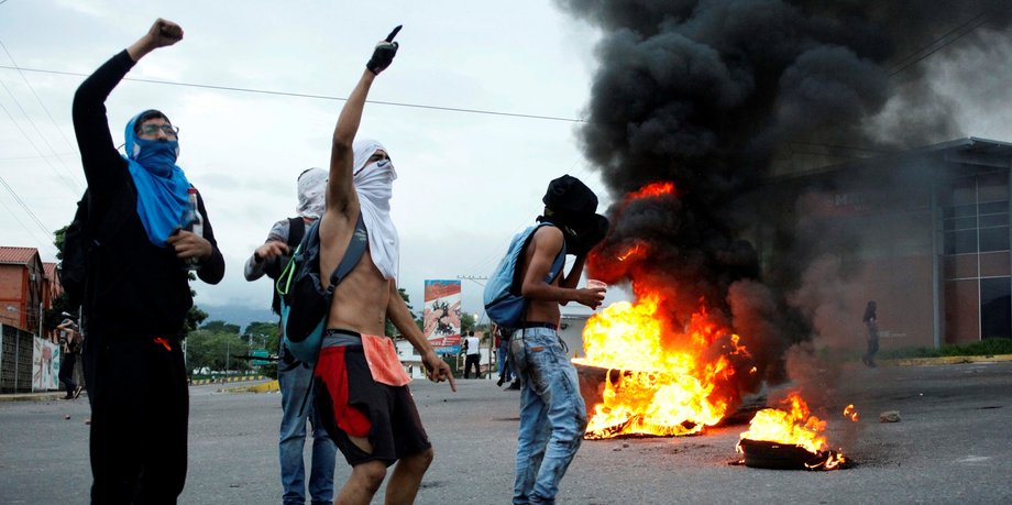 Opposition supporters shout as they burn tires during a protest to demand a referendum to remove President Nicolas Maduro in San Cristobal, Venezuela, May 18, 2016.