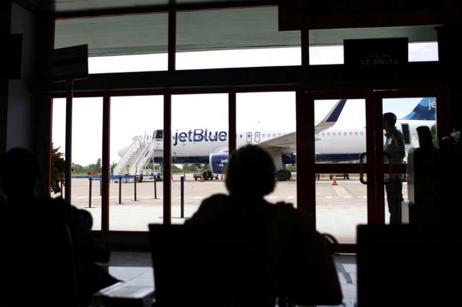 Passengers wait as a just-landed plane from JetBlue, the first commercial scheduled flight between the US and Cuba in more than 50 years, is seen at the Abel Santamaria International Airport in Santa Clara, Cuba, August 31, 2016.