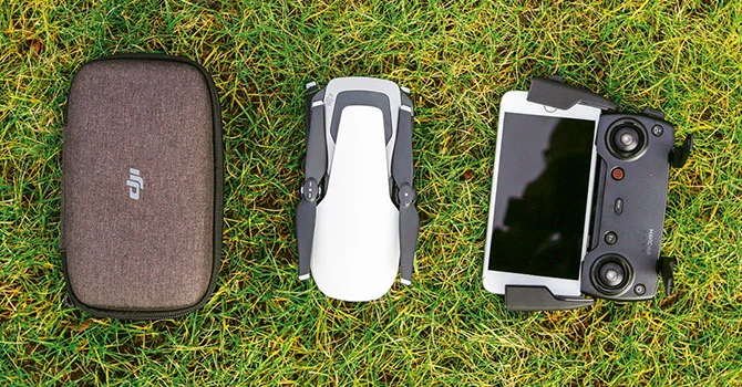 DJI Mavic Air po złożeniu jest niewiele większy od iPhone'a 8 Plus, który po prawej stronie jest wpięty do pilota. Pudełko do transportu drona mieści się w prawie każdej kieszeni.
